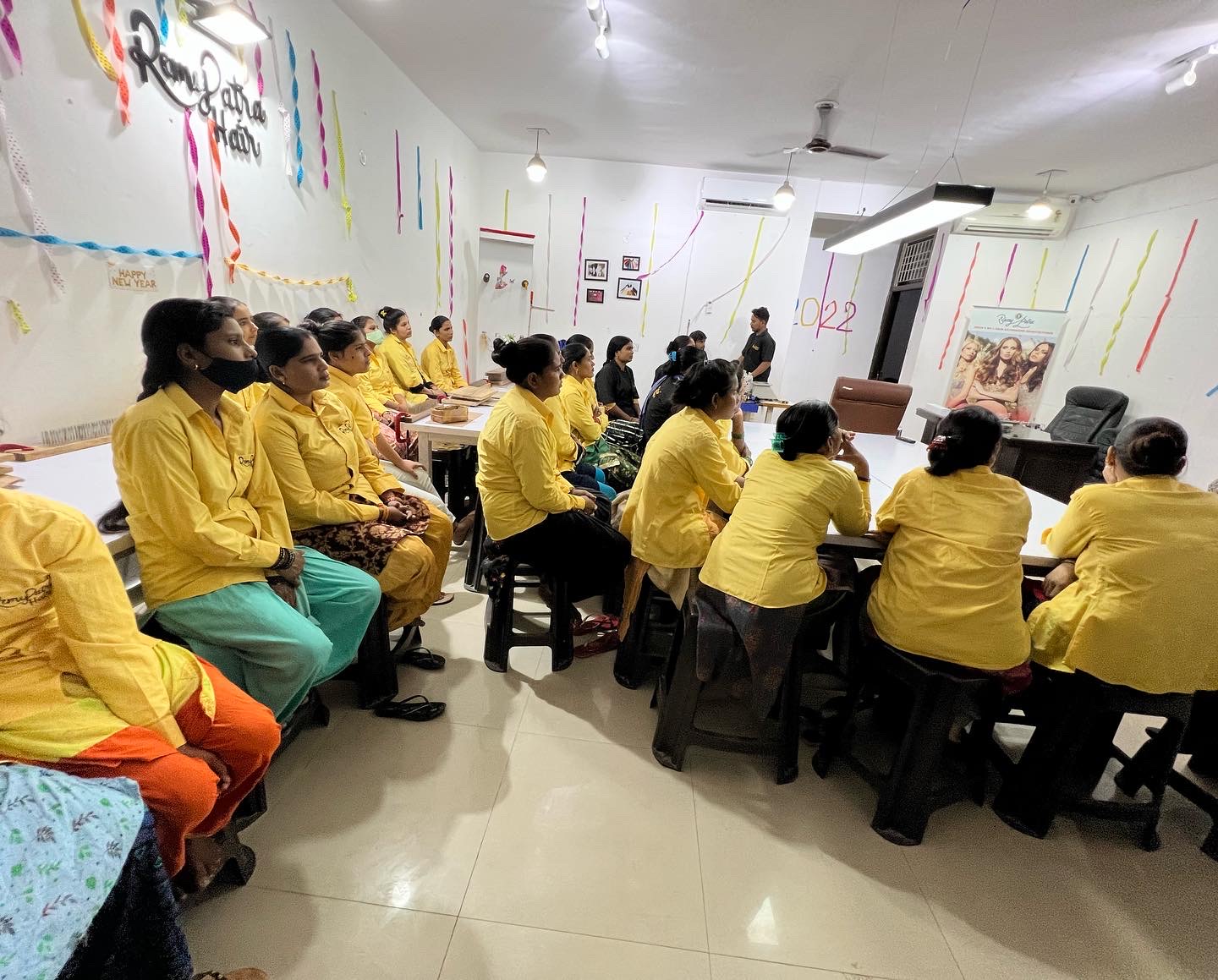 The RemyPatra team gathered in the factory training room beneath the RemyPatra Hair wall sign