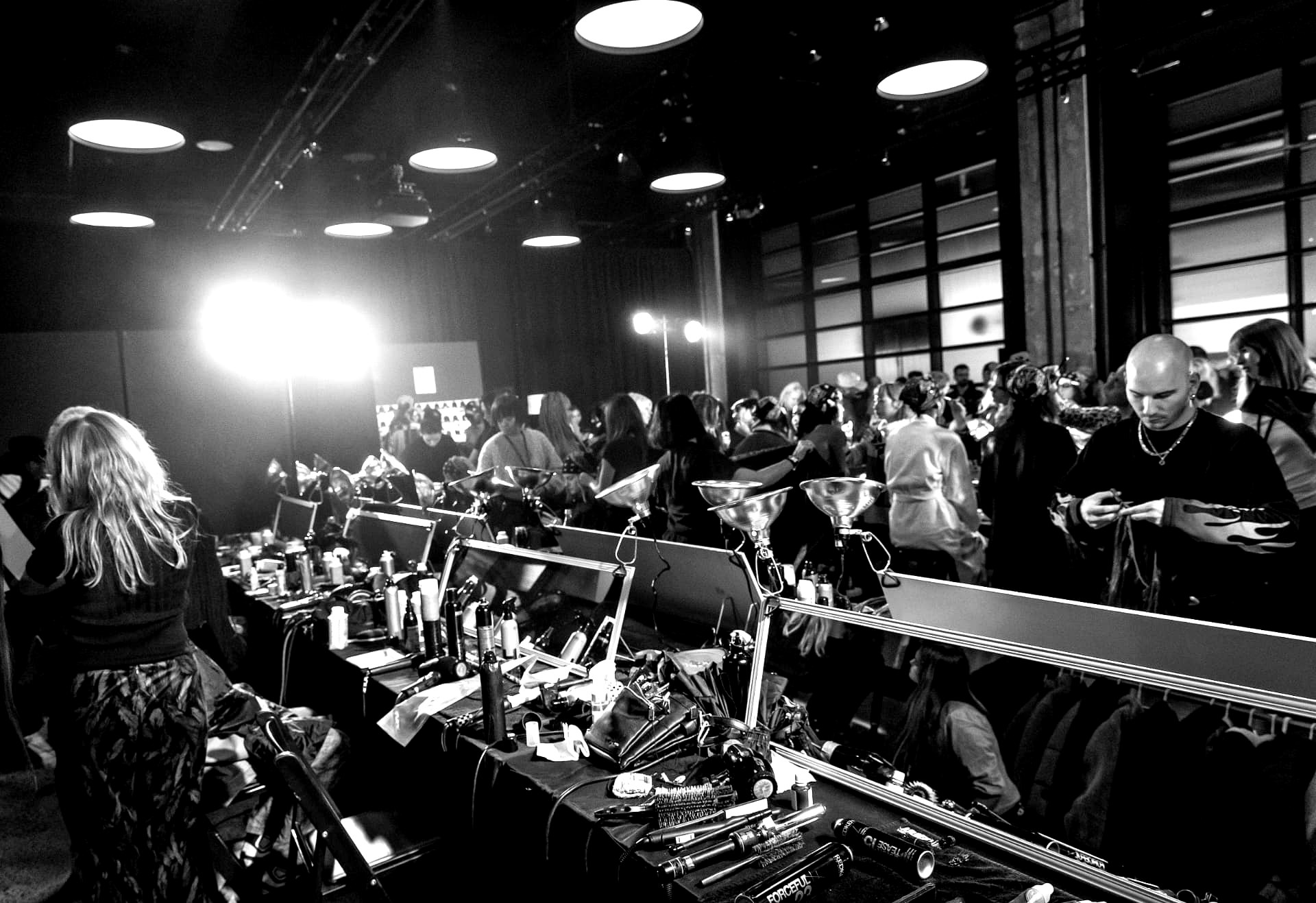 Row of backstage styling stations with lights, tools and mirrors