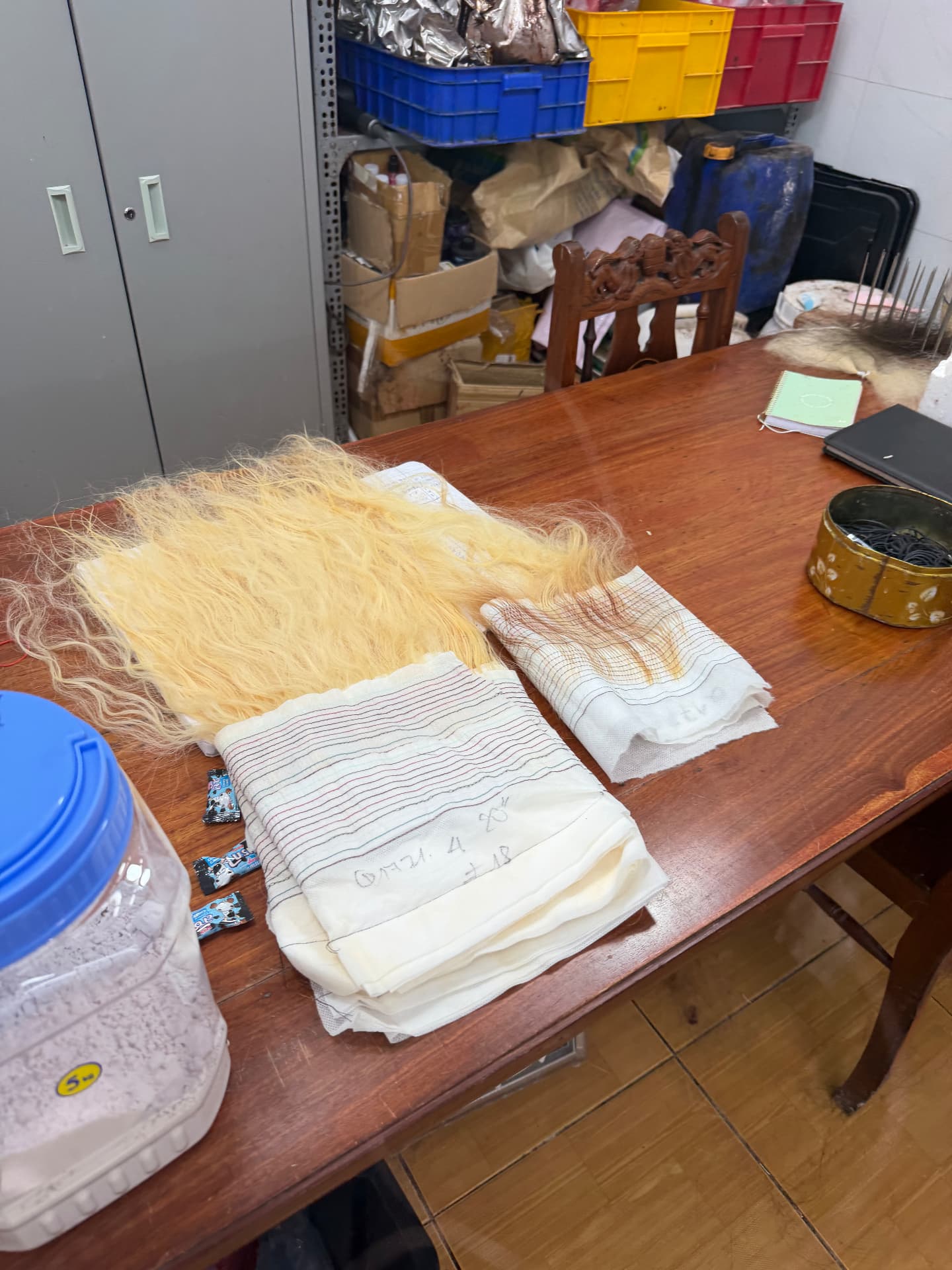 Bleached blonde wefts laid out on the inspection table with their written length and weight notes