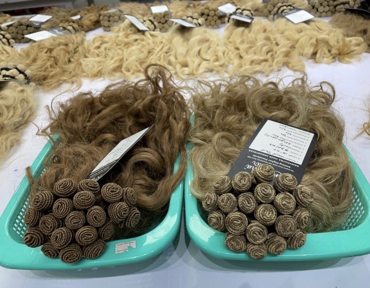 Production table with tagged lots and loose blonde bulk hair