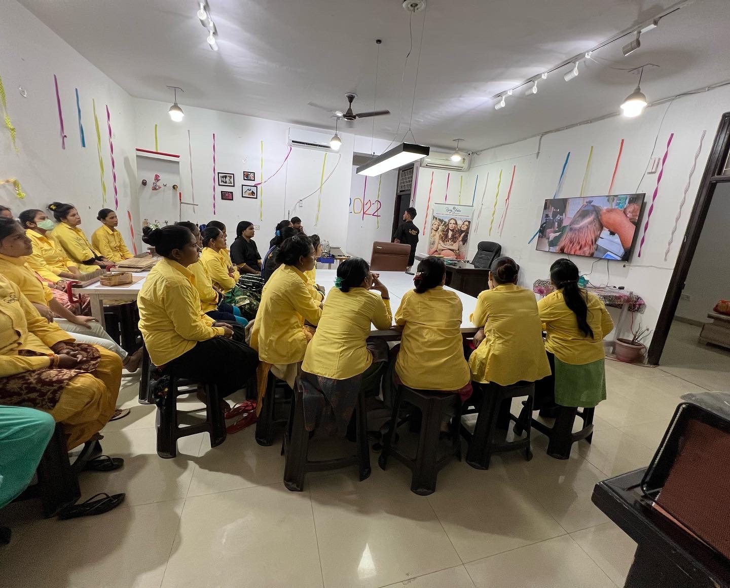 Team briefing at the RemyPatra factory with the production tables along the wall