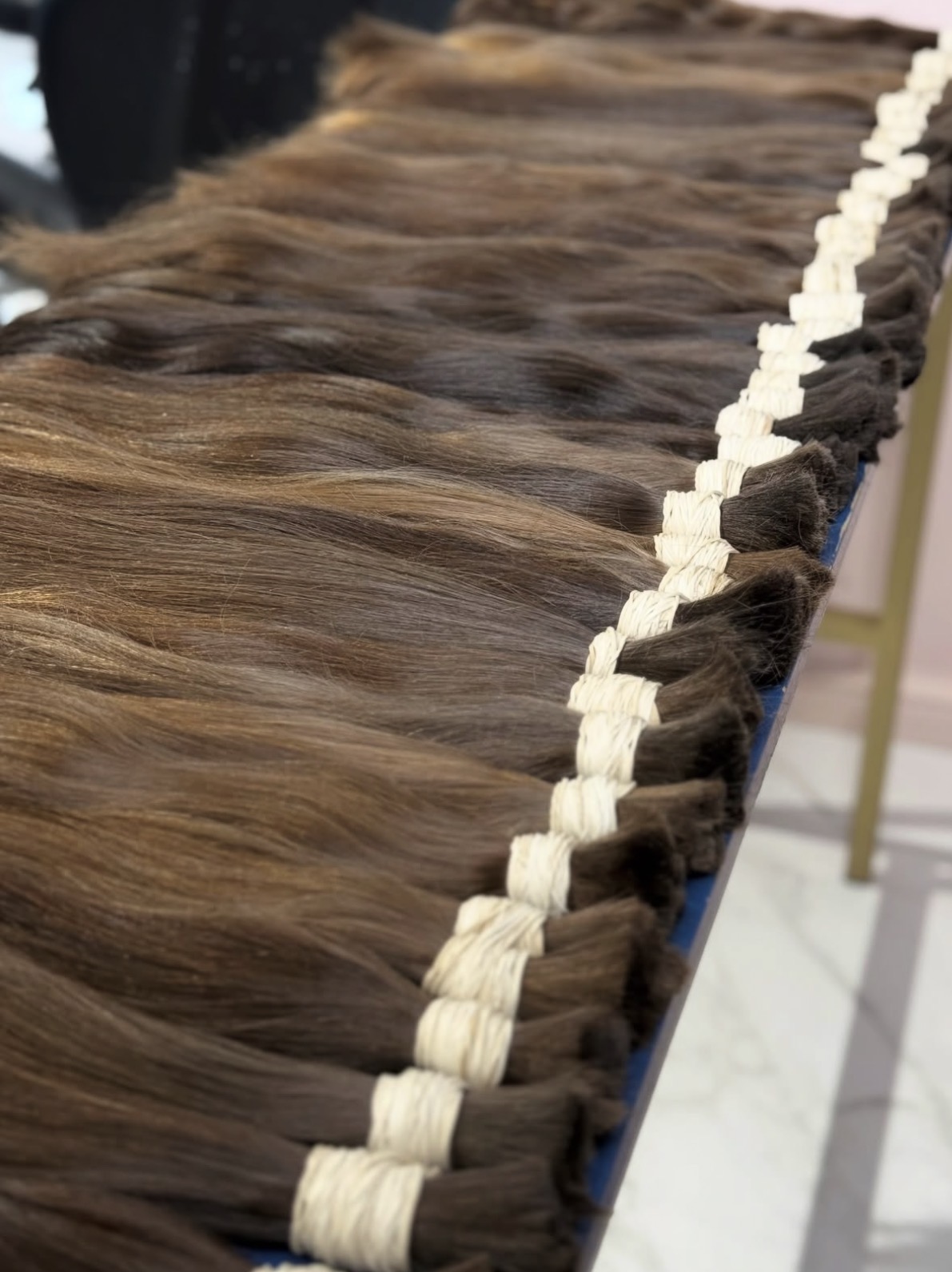Angled view of the export line of single drawn brown hair bundles