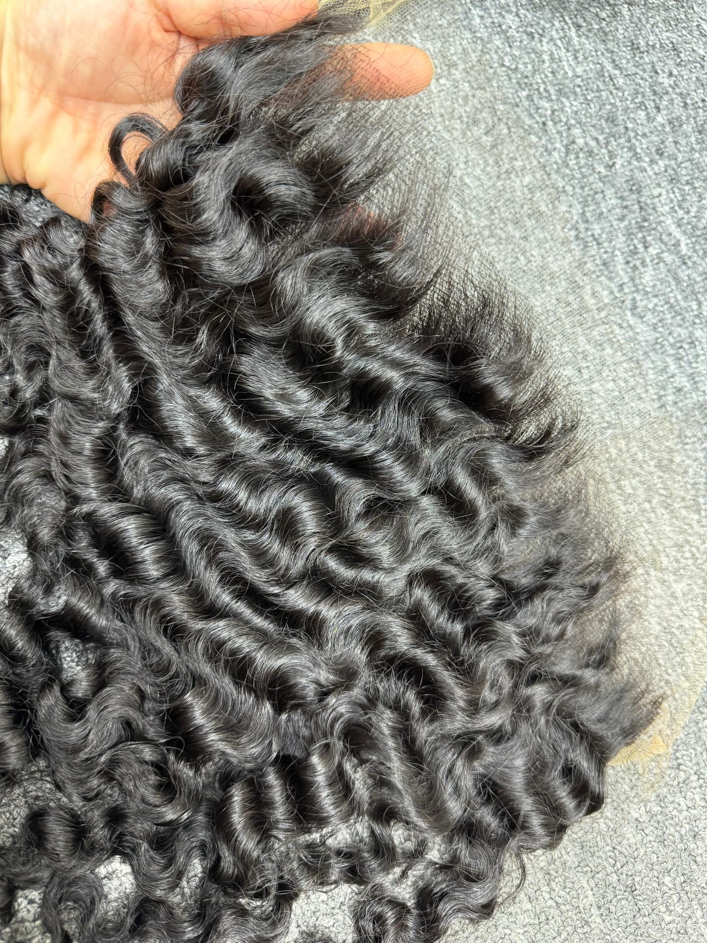 Close detail of curly temple hair meeting the lace of a frontal
