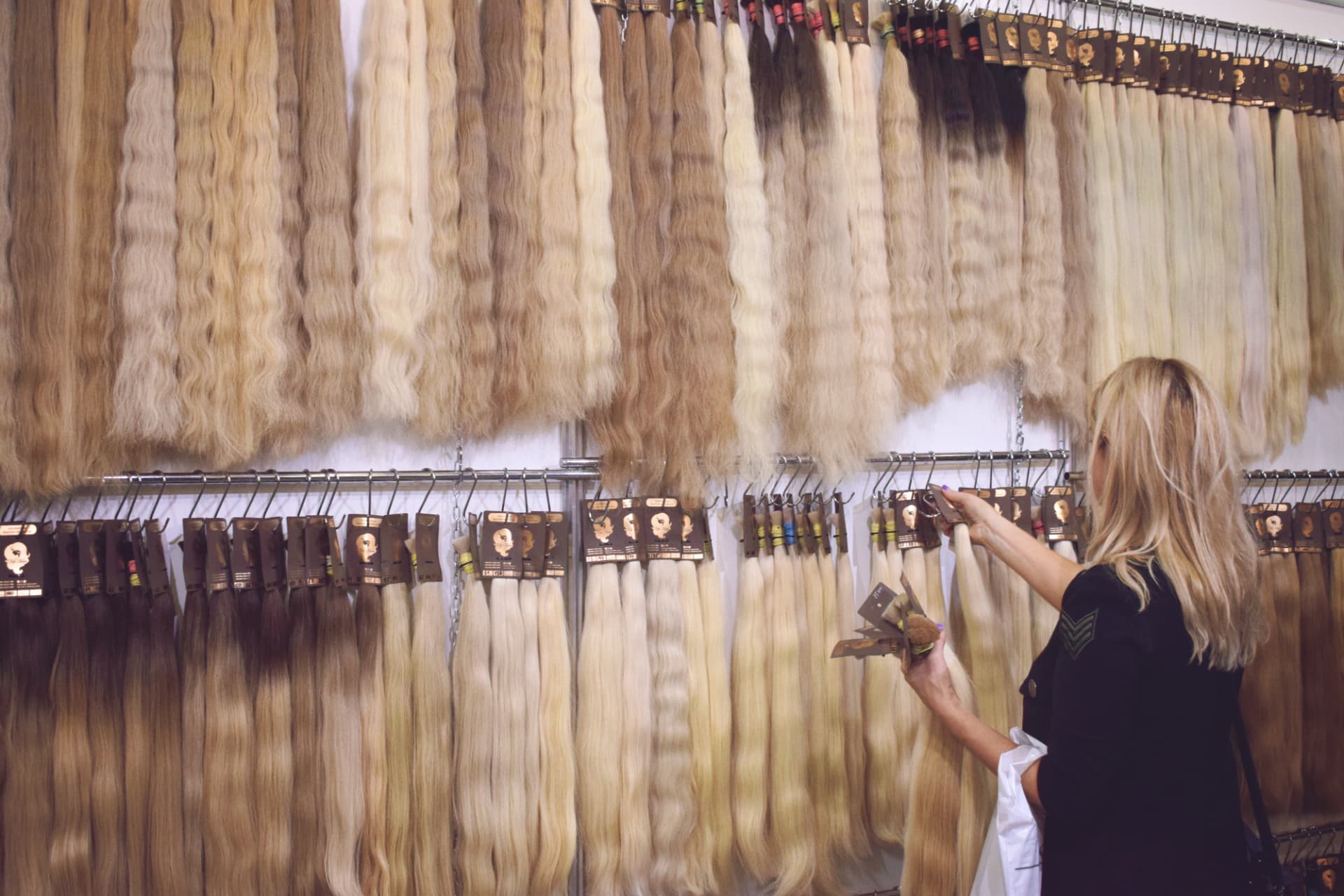 Buyer browsing a colour wall of extensions in a stockist store