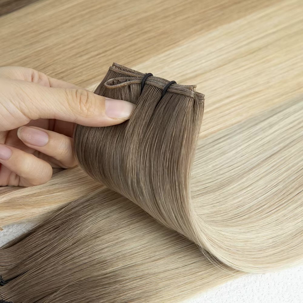 Hand lifting a flexible rooted blonde Genius Weft
