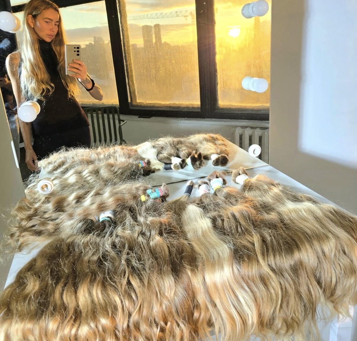 Virgin hair buyer inspecting a full table of naturally light hair bundles