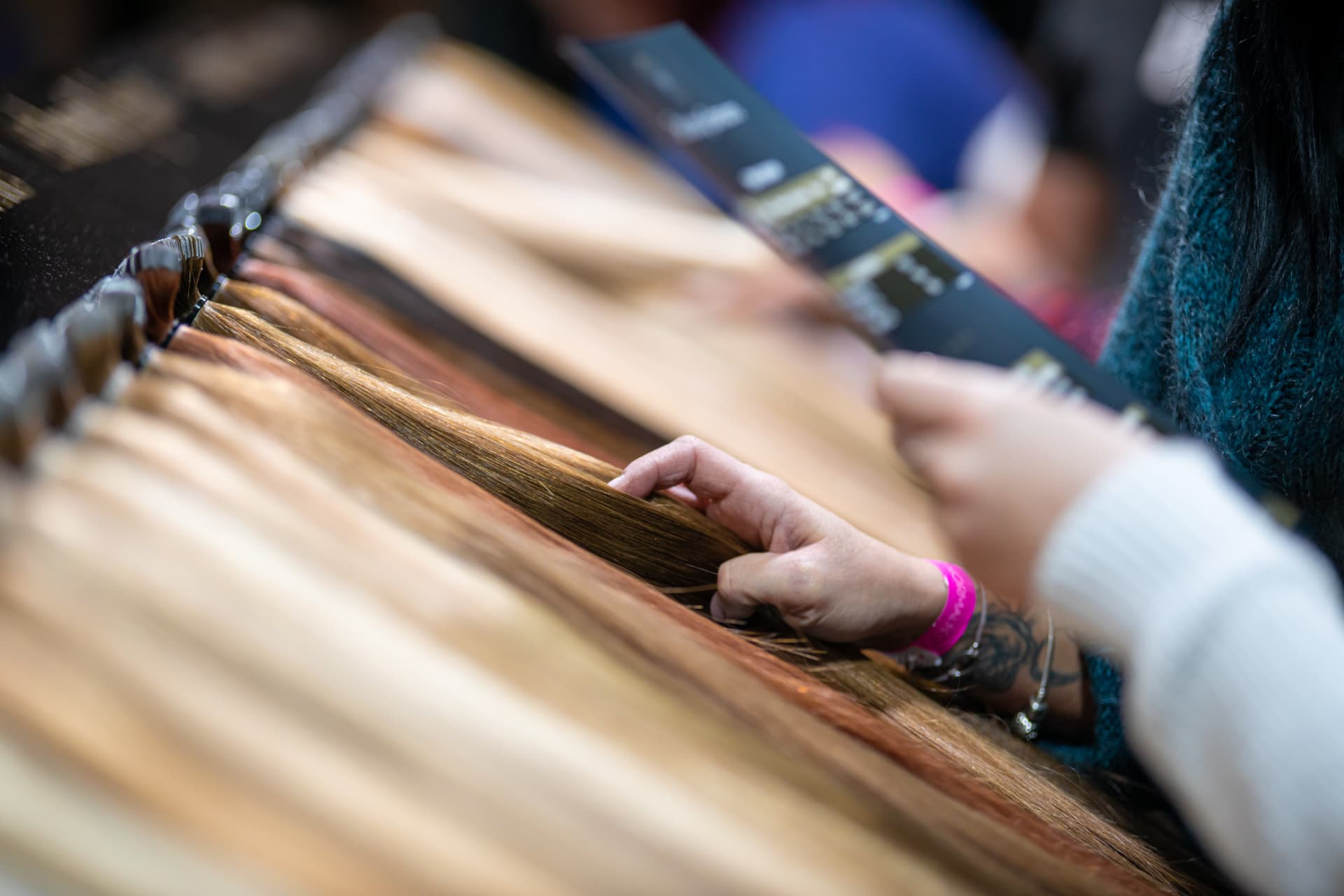 A buyer judging hair by hand at a trade counter