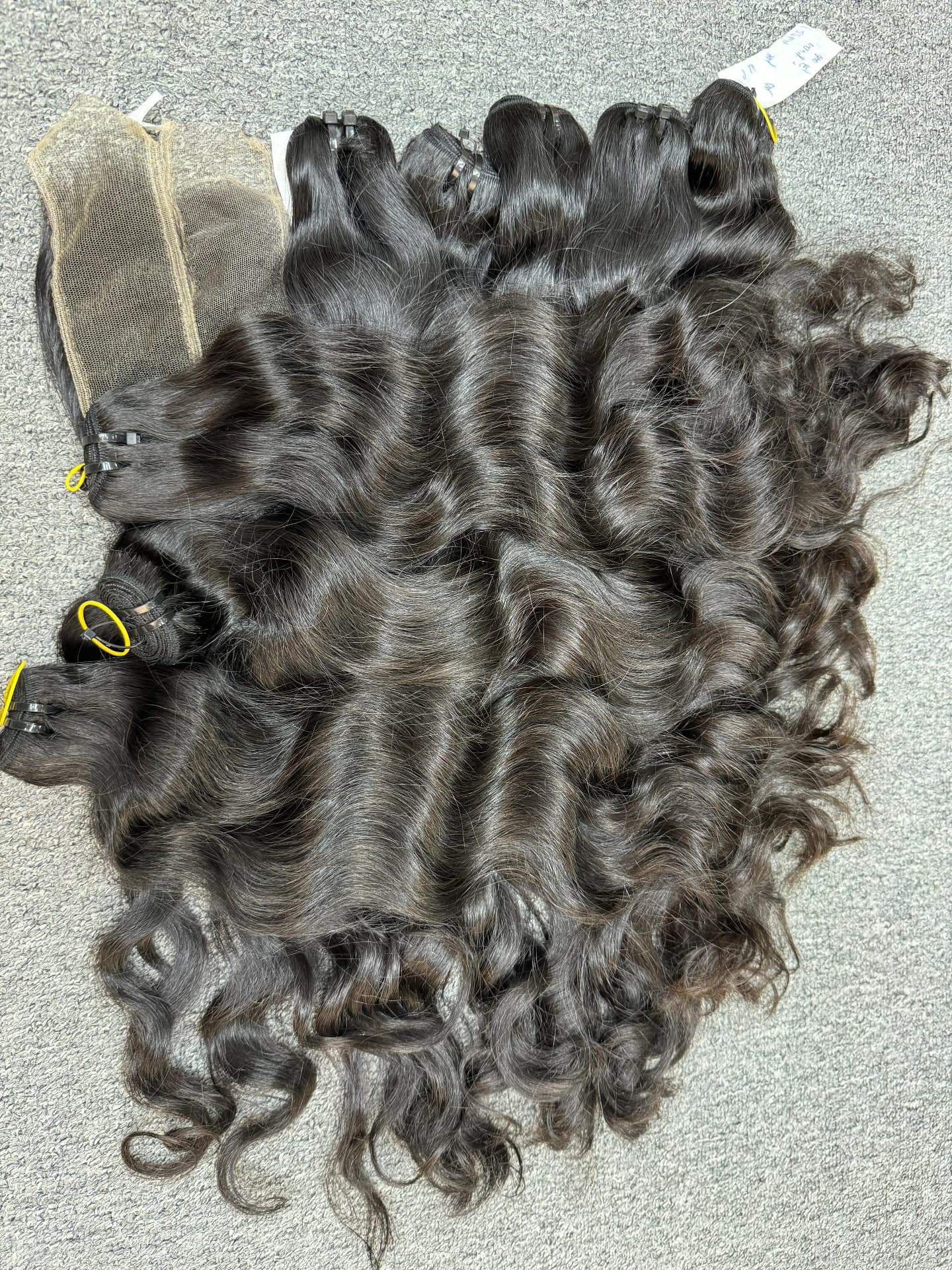 Wavy temple-hair bundles laid out with matching lace closures before grading