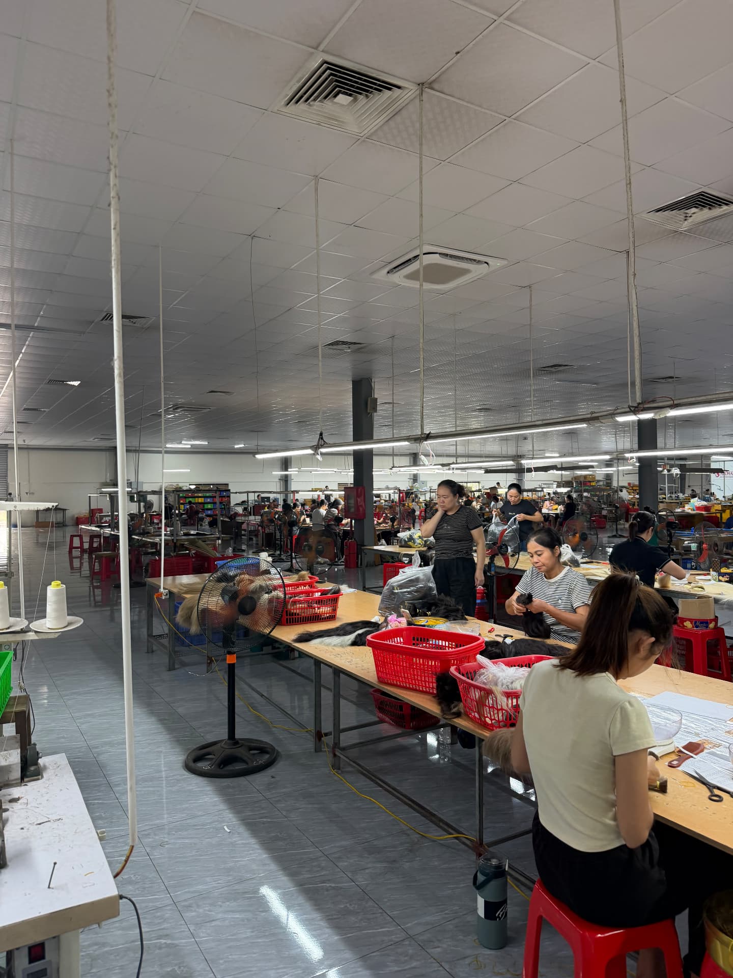 Wide view of the RemyPatra Manipur factory with production teams working across the hair preparation tables