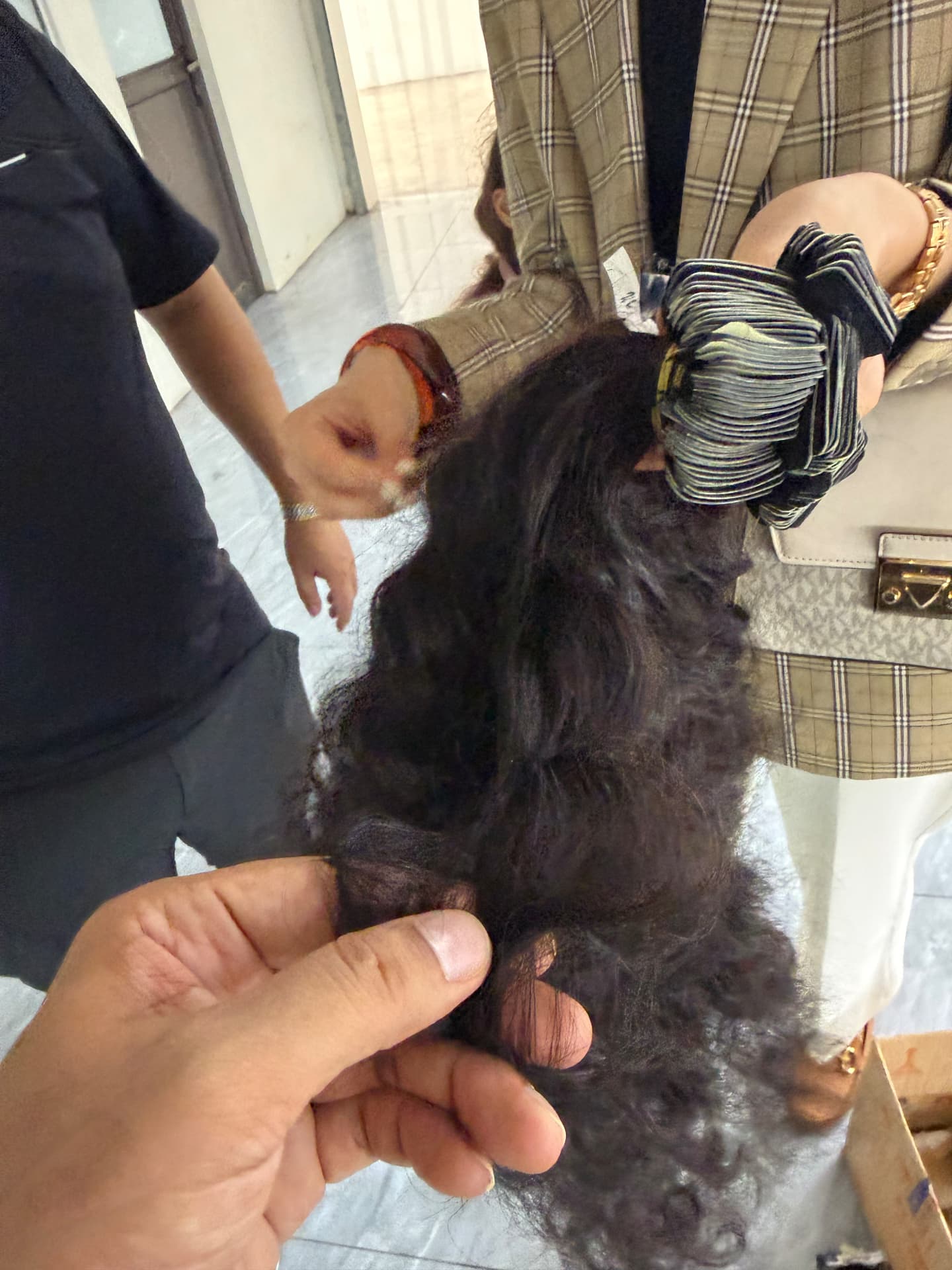 Curly natural hair and prepared attachment pieces checked together during production