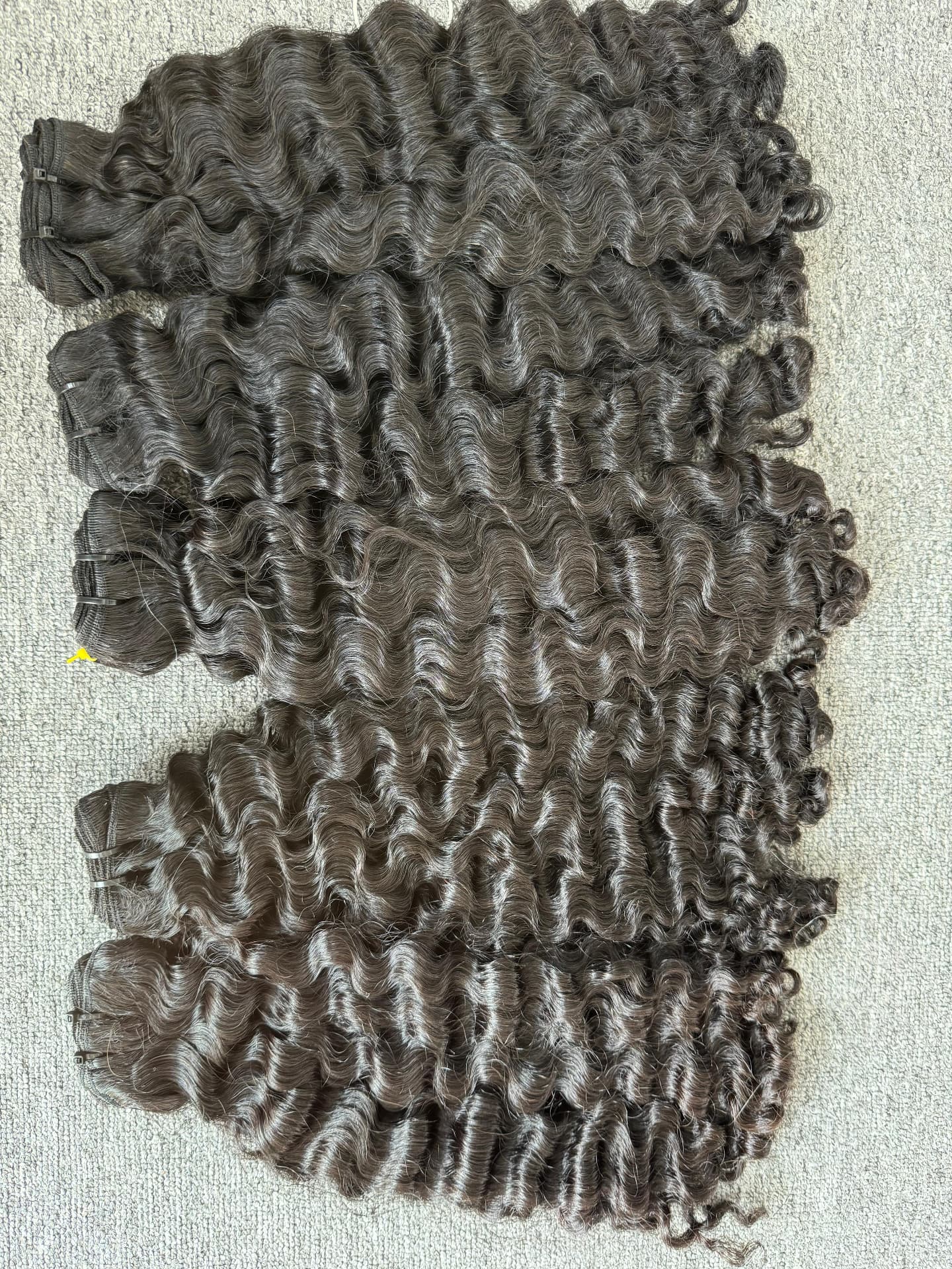 Deep wave temple-hair bundles showing consistent curl through the length