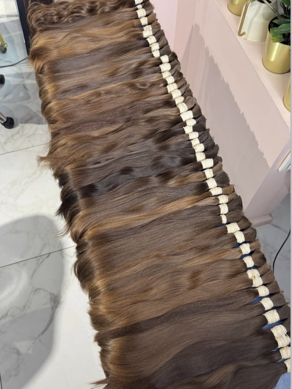 Overhead view of graded brown virgin bundles arranged by shade before packing