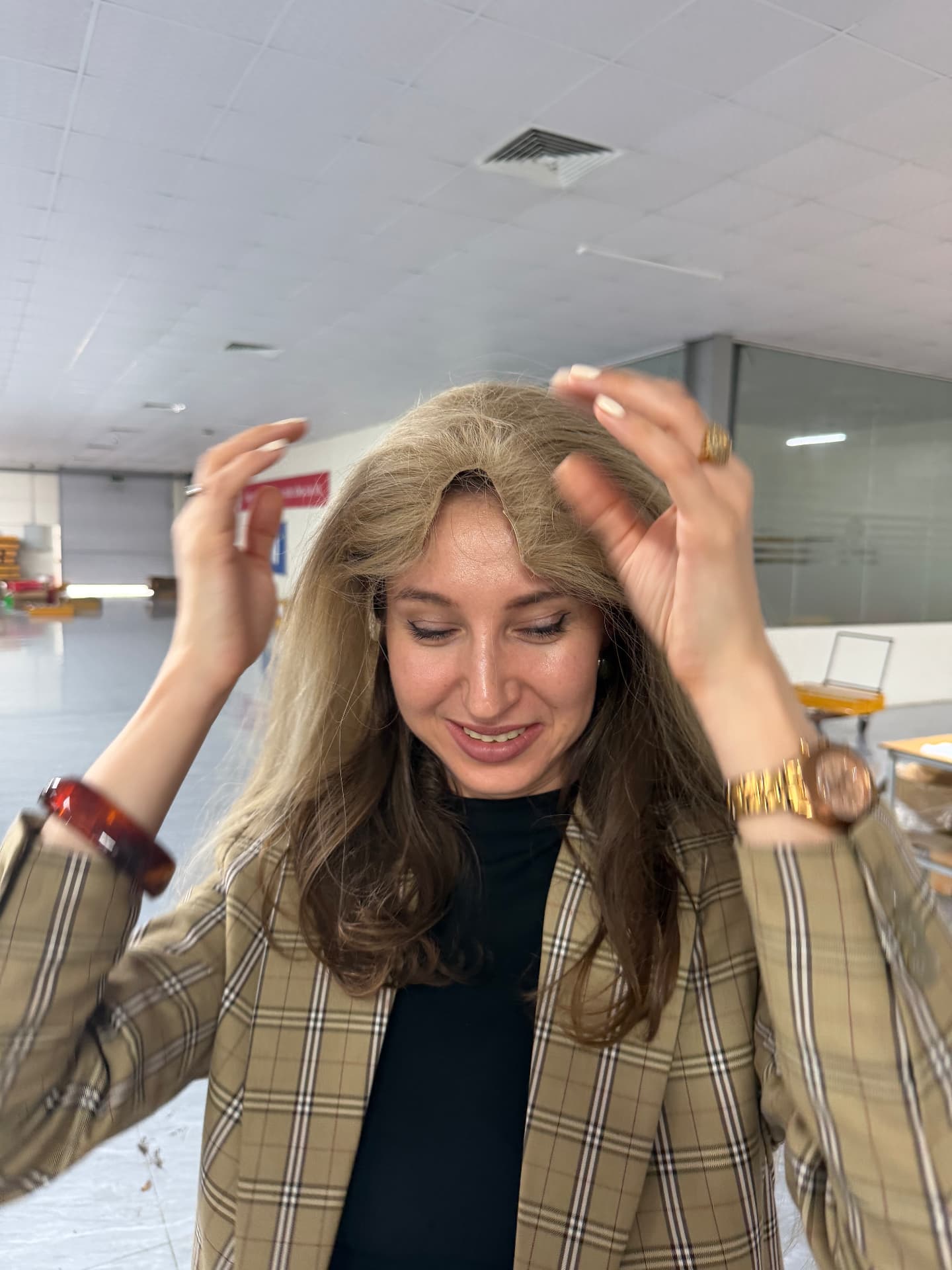 A finished dimensional blonde and brown hairpiece tried on inside the Manipur factory