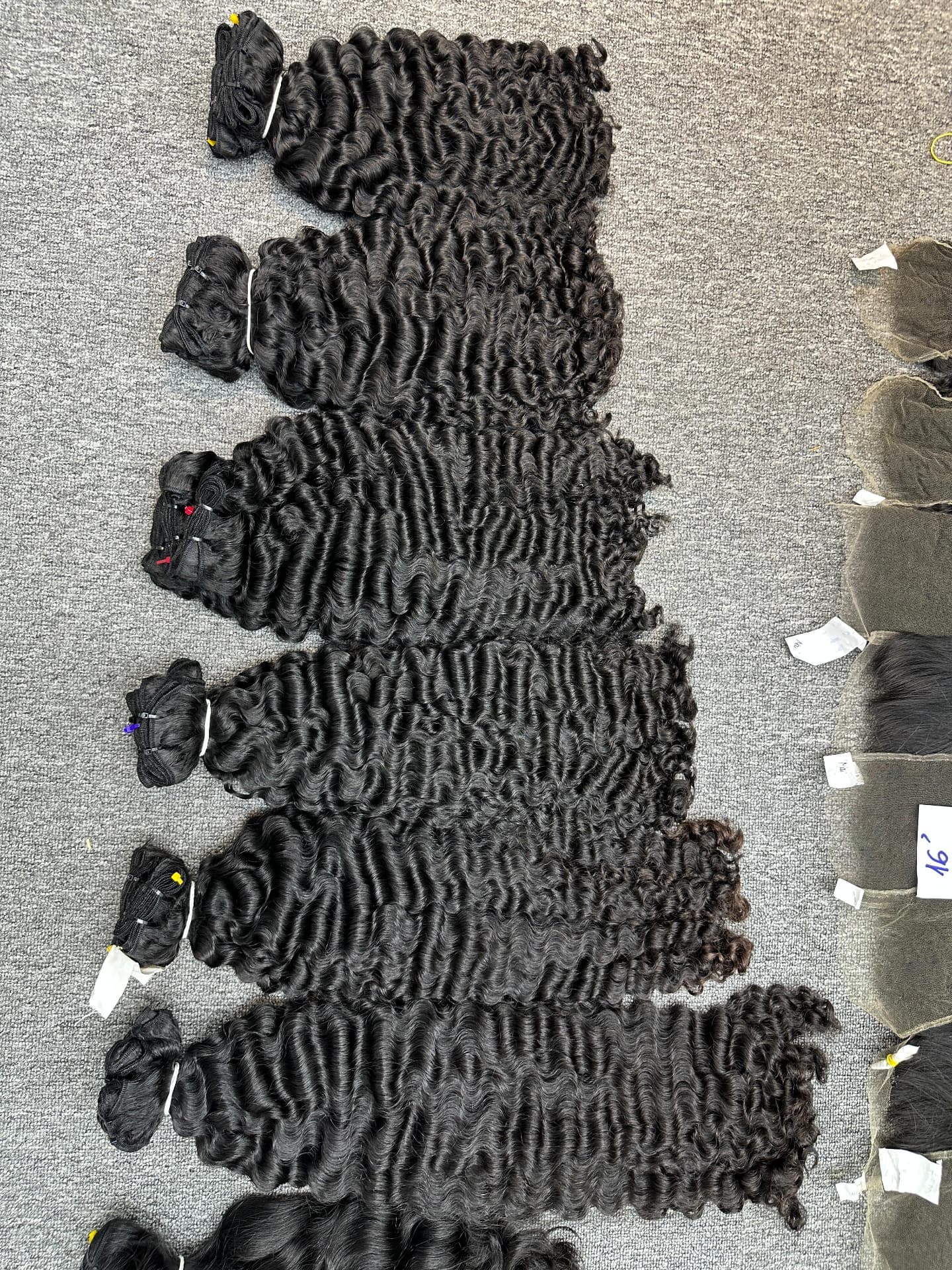 Deep curly temple-hair wefts sorted by length on the factory